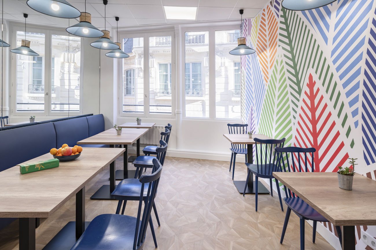 Espace convivial des bureaux du Sentier à Paris, banquette bleue et mur graphique coloré