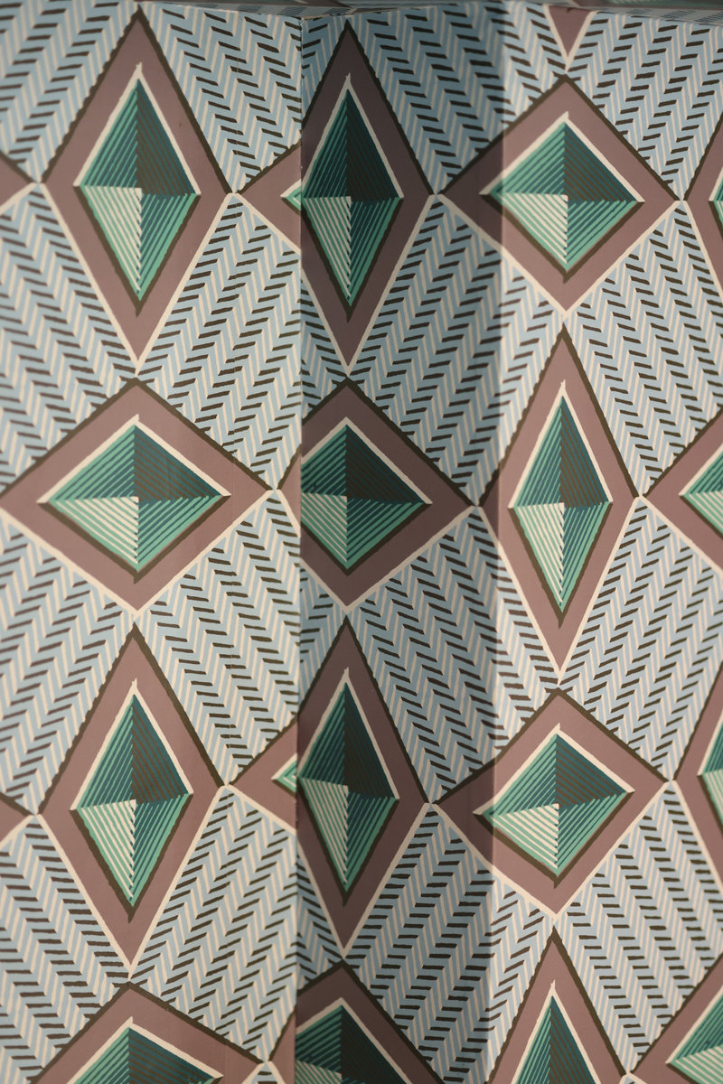 Papier peint aux motifs géométriques dans une arche des boiseries